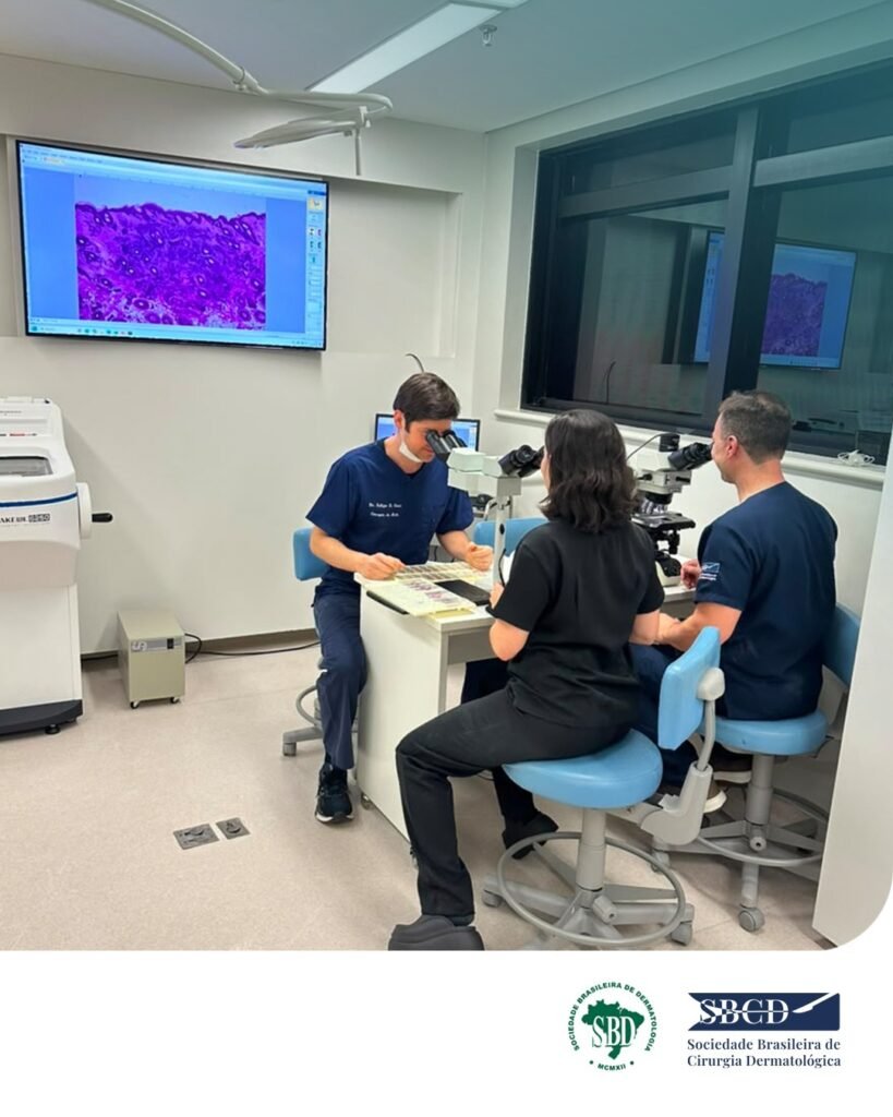 Alunos analisando lâminas no microscópio durante o curso de cirurgia de Mohs